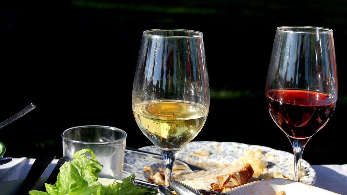 Sommerliche Tafel im Freien mit Wein, Salat und Oliven