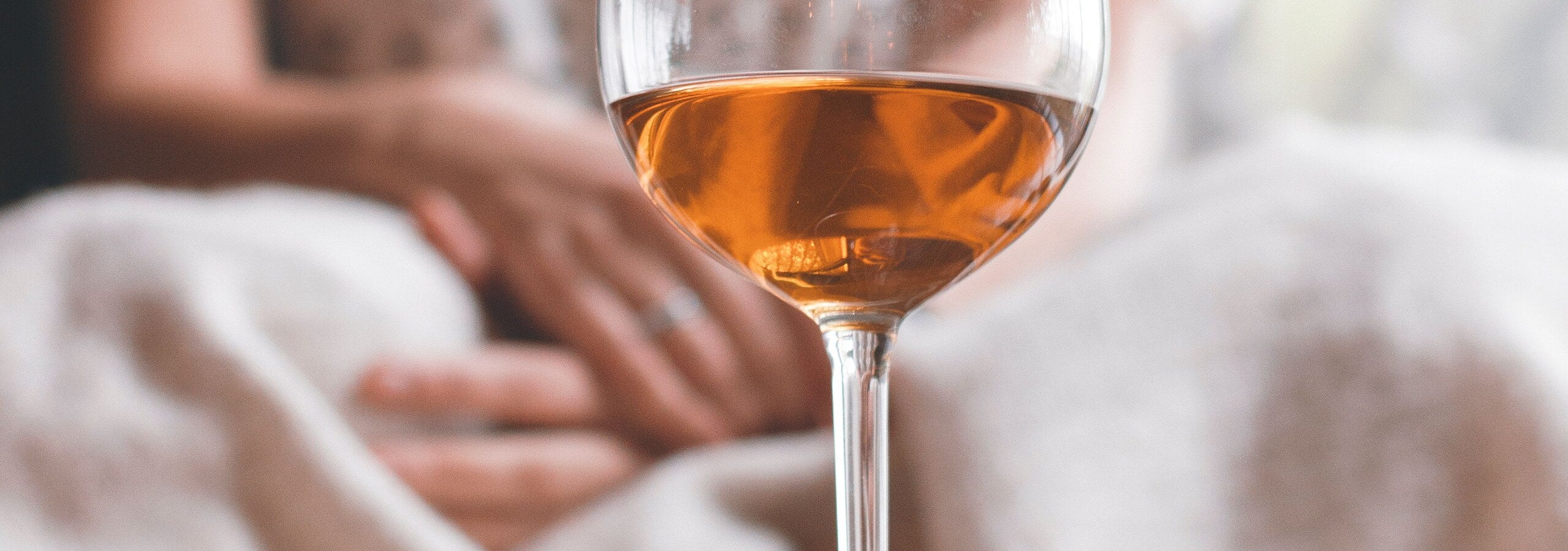 Glas Orange Wein in warmem Bernsteinton im Fensterlicht
